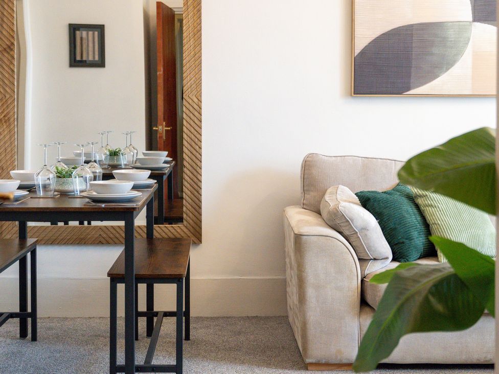 A dining room with a table set for meals at The Gilder Birmingham City Apartment in Birmingham