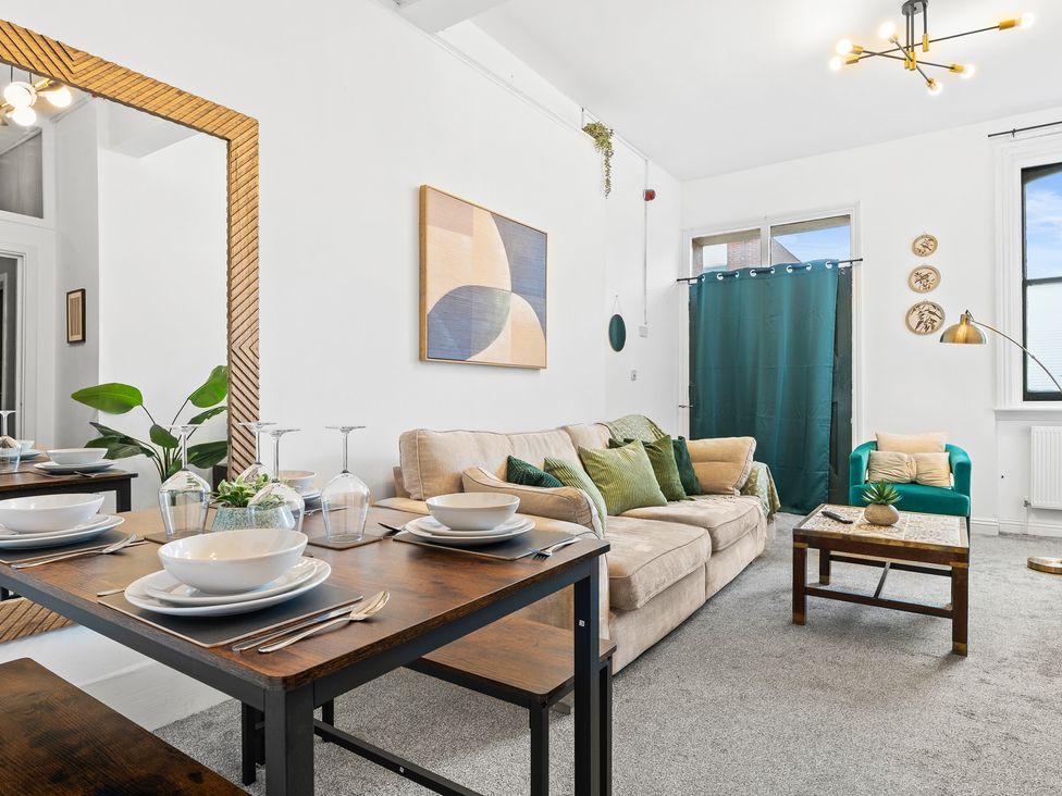 A living room with a sofa and dining table at The Gilder Birmingham City Apartment, Birmingham