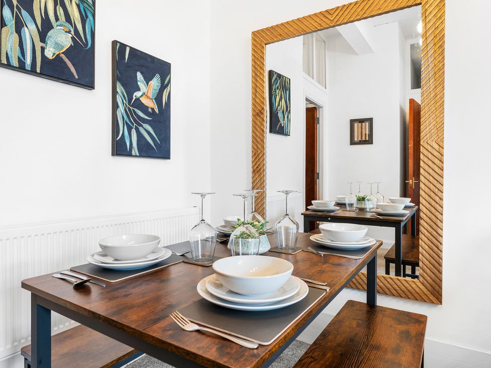 A dining room with set table and artwork at The Gilder Birmingham City Apartment Birmingham