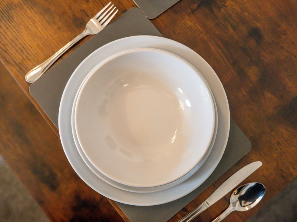 A dining table set with plates and utensils at The Gilder Birmingham City Apartment Birmingham