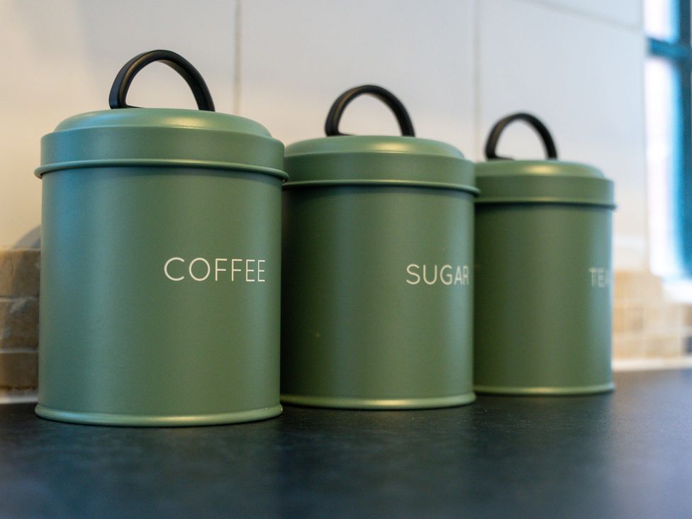 Three canisters labeled coffee, sugar, and tea in a kitchen at The Gilder Birmingham City Apartment Birmingham