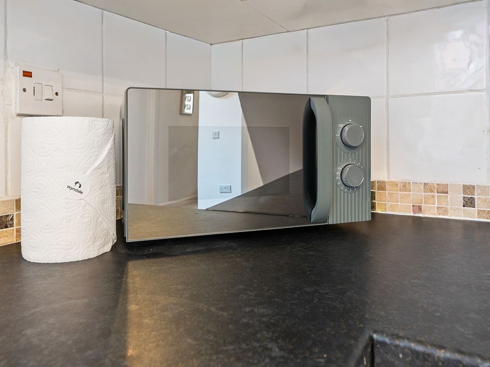 A microwave and paper towel roll in the kitchen at The Gilder Birmingham City Apartment Birmingham