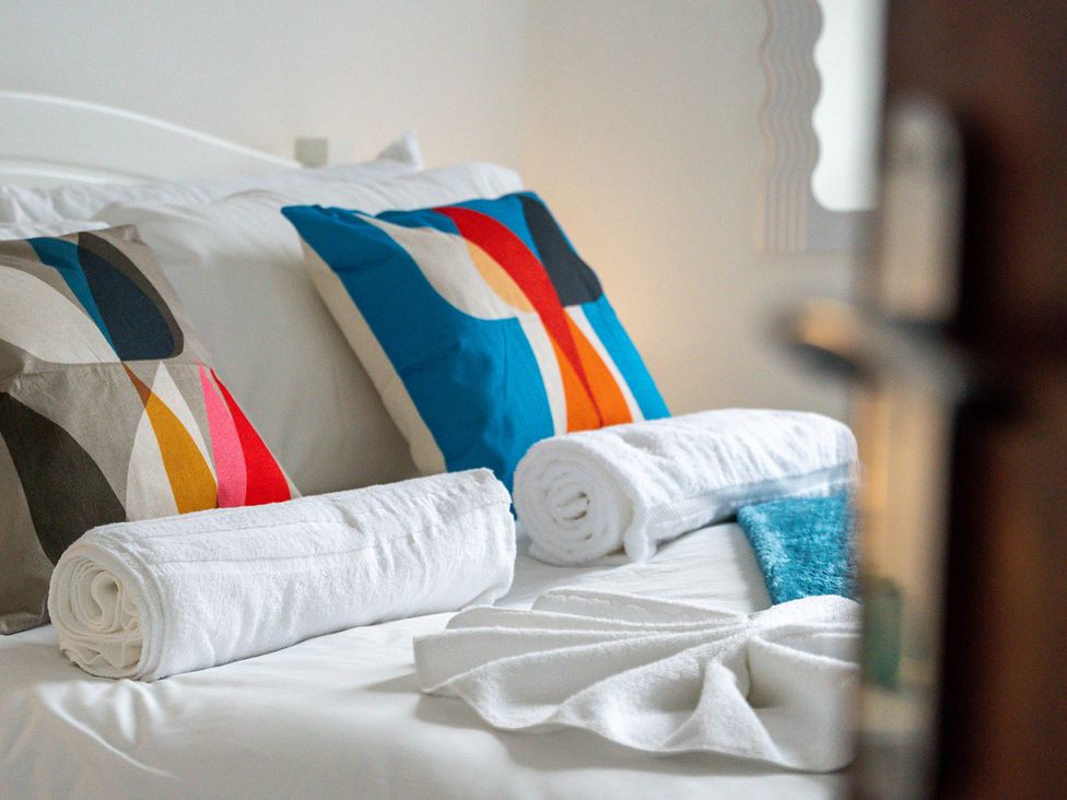A bed with decorative pillows and rolled towels at The Gilder Birmingham City Apartment Birmingham