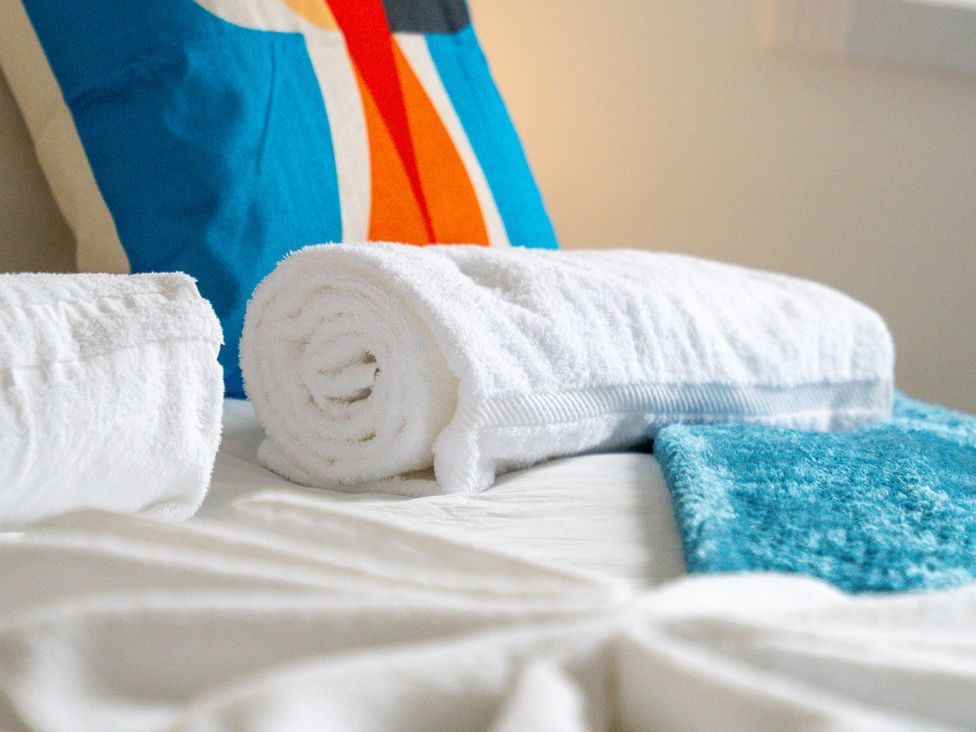 A bed with towels and pillows at The Gilder Birmingham City Apartment Birmingham