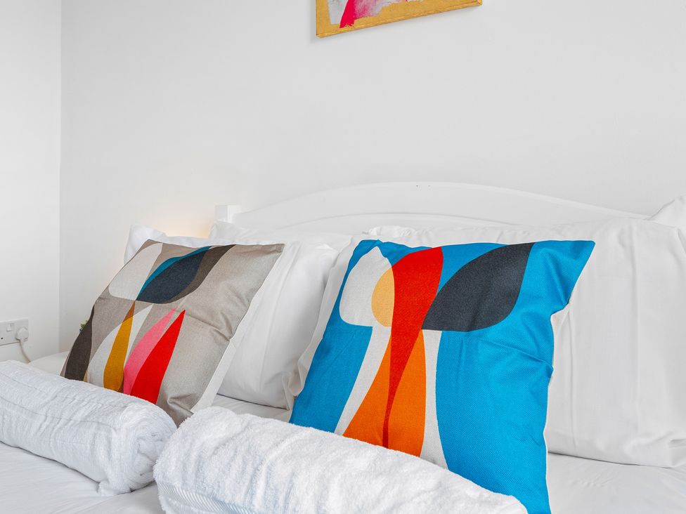 A bedroom with decorative pillows and towels at The Gilder Birmingham City Apartment in Birmingham