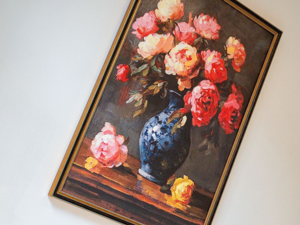 A painting of flowers in a vase on a wall at The Gilder Birmingham City Apartment, Birmingham