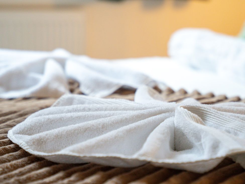 A bed with towels arranged on the bedding at The Gilder Birmingham City Apartment Birmingham