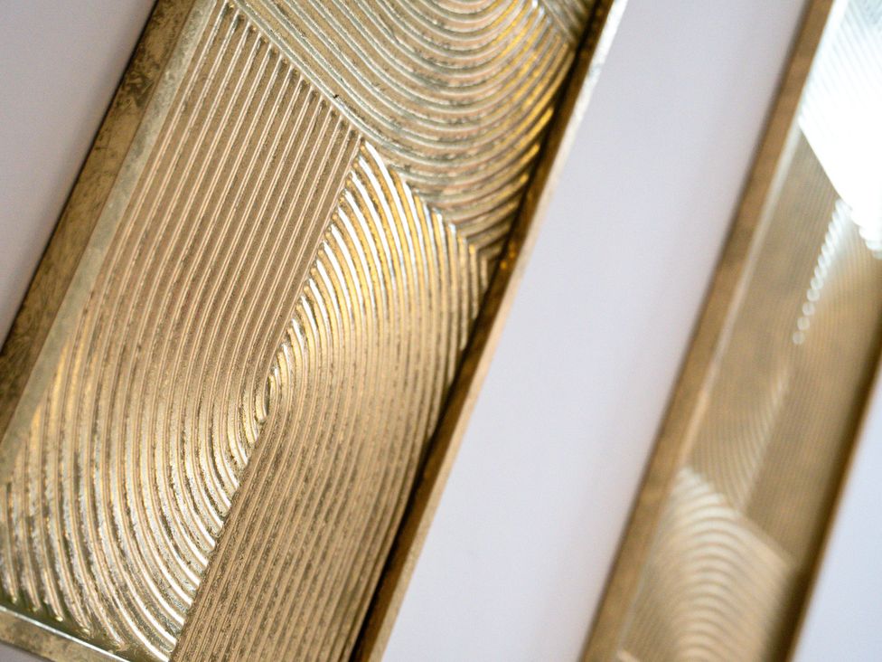 Decorative wall panels with gold finish at The Gilder Birmingham City Apartment in Birmingham