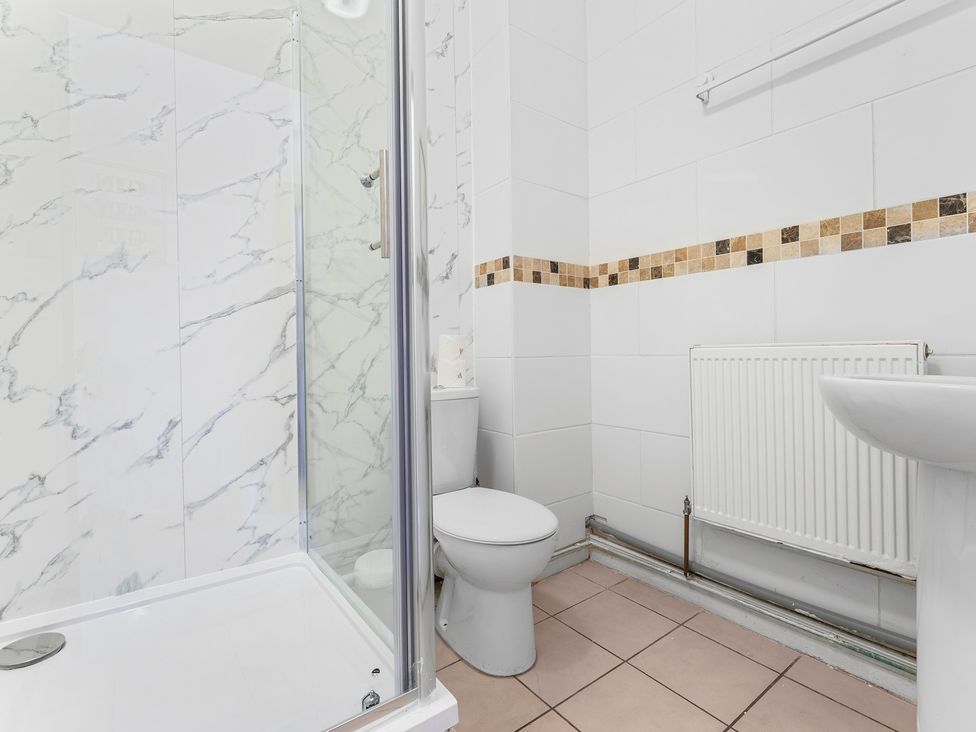 A bathroom with a shower, toilet, and sink at The Gilder Birmingham City Apartment in Birmingham