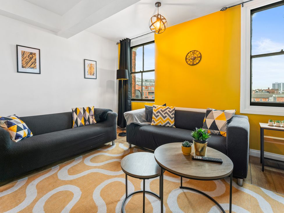 A living room with two sofas and a table at The Craftsman Birmingham City Apartment Birmingham
