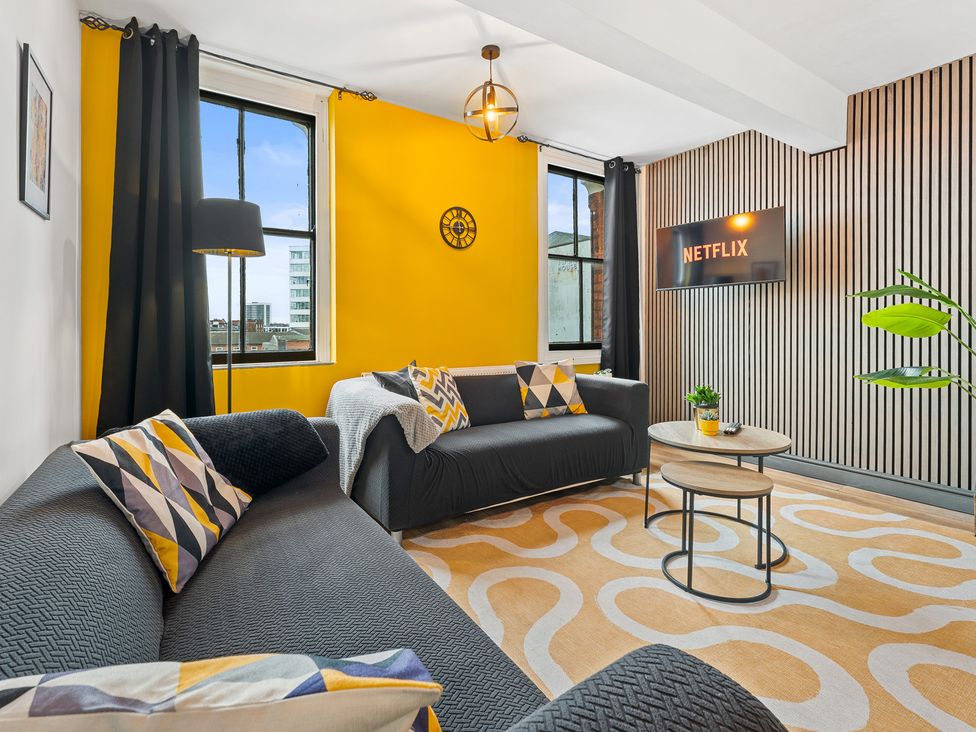 A living room with a sofa and television at The Craftsman Birmingham City Apartment in Birmingham