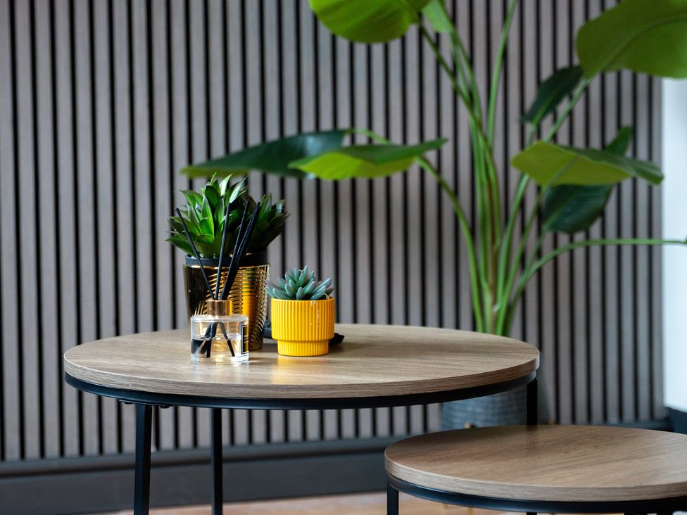 A living room with a table and plants at The Craftsman Birmingham City Apartment Birmingham