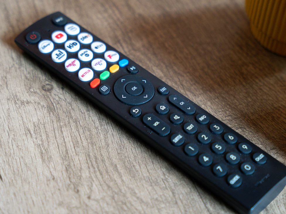 A remote control on a wooden surface at The Craftsman Birmingham City Apartment in Birmingham