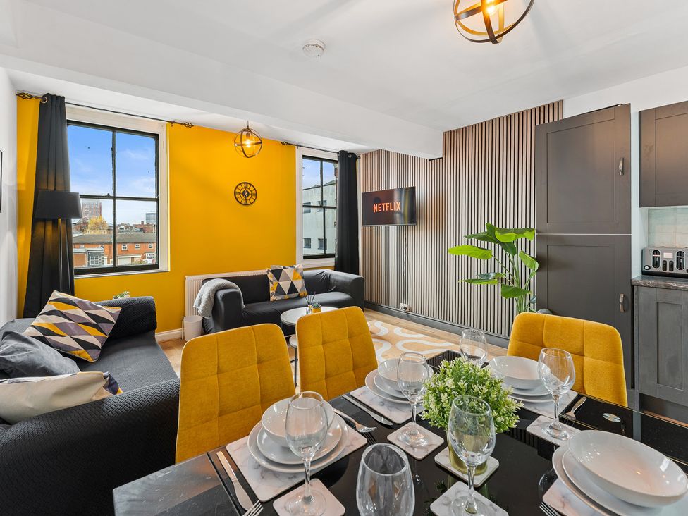 A living room with a dining area and a TV at The Craftsman Birmingham City Apartment in Birmingham
