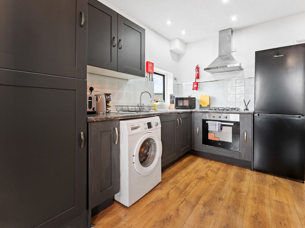 A kitchen featuring cabinets, a washing machine, and an oven at The Craftsman Birmingham City Apartment in Birmingham