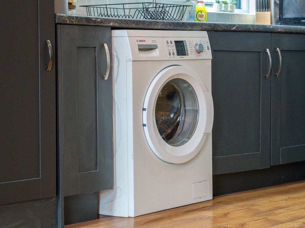A washing machine in a kitchen at The Craftsman Birmingham City Apartment Birmingham