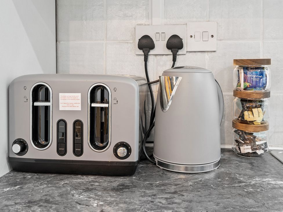 A toaster and kettle on a countertop at The Craftsman Birmingham City Apartment Birmingham