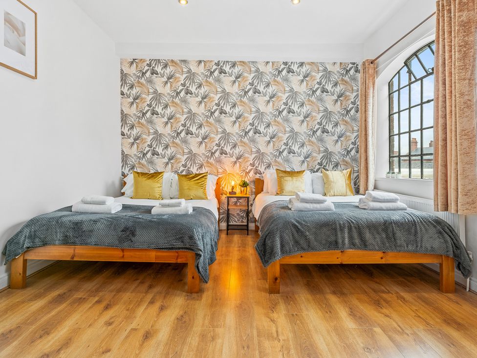 A bedroom with two beds and a lamp at The Craftsman Birmingham City Apartment Birmingham