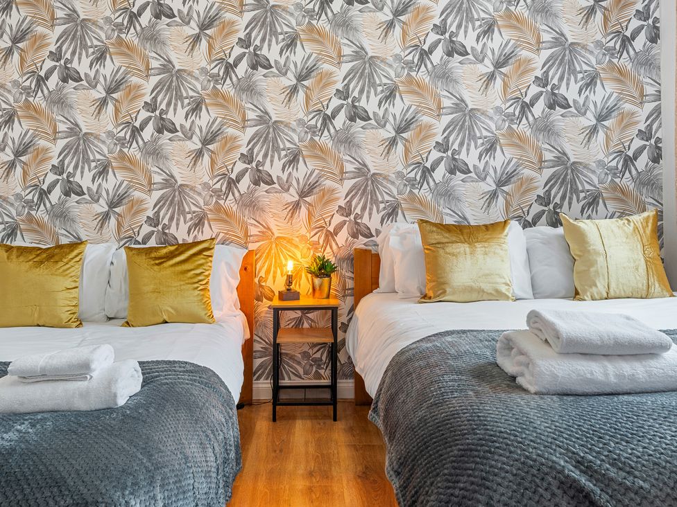 A bedroom with two beds and a bedside table at The Craftsman Birmingham City Apartment Birmingham