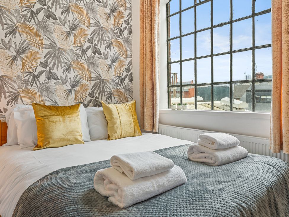 A bedroom with a bed and large window at The Craftsman Birmingham City Apartment in Birmingham