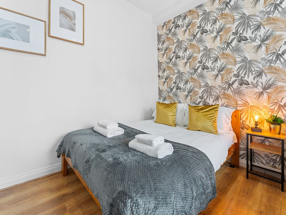 A bedroom with a bed and wall art at The Craftsman Birmingham City Apartment Birmingham
