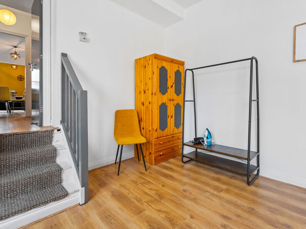 A hallway with a staircase and seating area at The Craftsman Birmingham City Apartment Birmingham