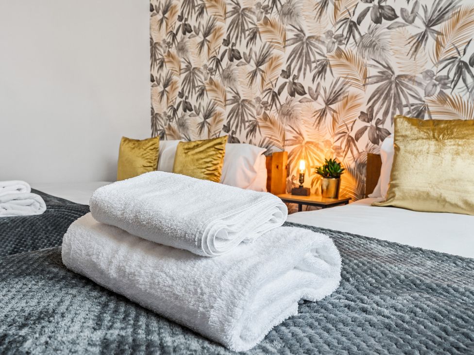 A bedroom with bedding and towels at The Craftsman Birmingham City Apartment Birmingham