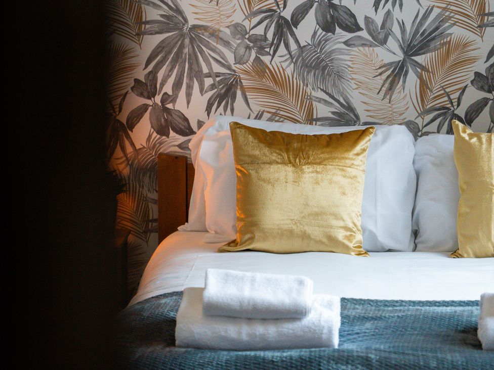 A bed with pillows and towels at The Craftsman Birmingham City Apartment Birmingham