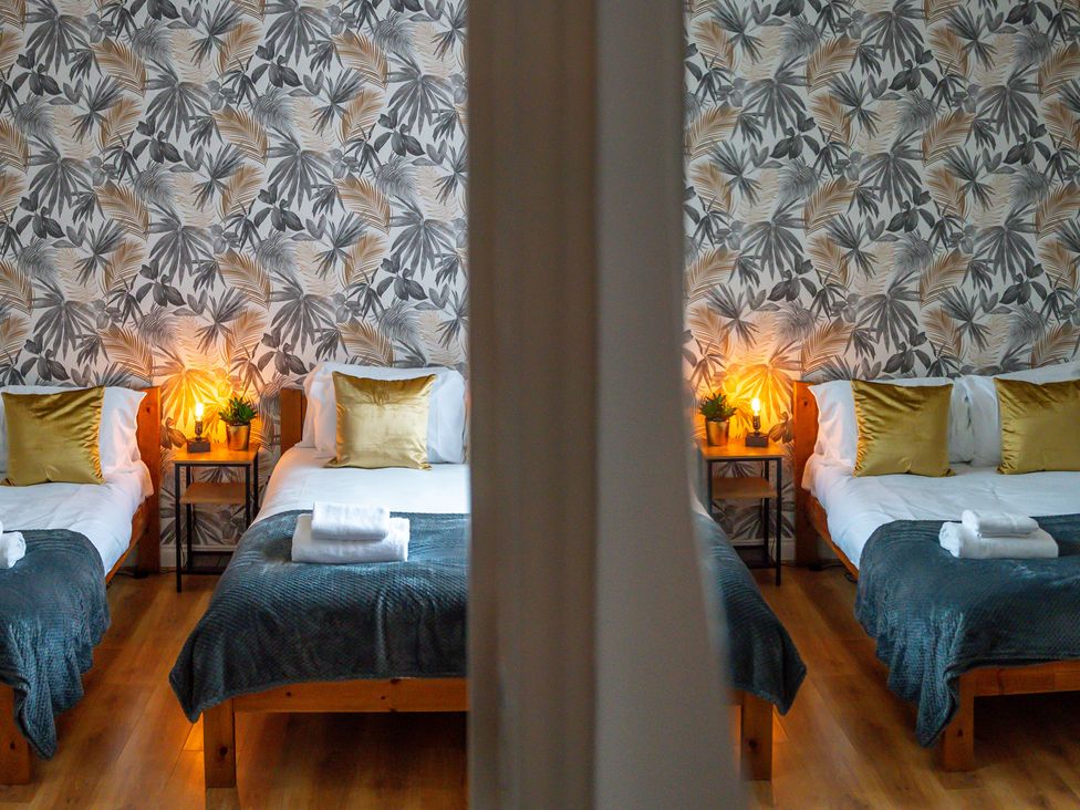 A bedroom with two beds and plants at The Craftsman Birmingham City Apartment Birmingham