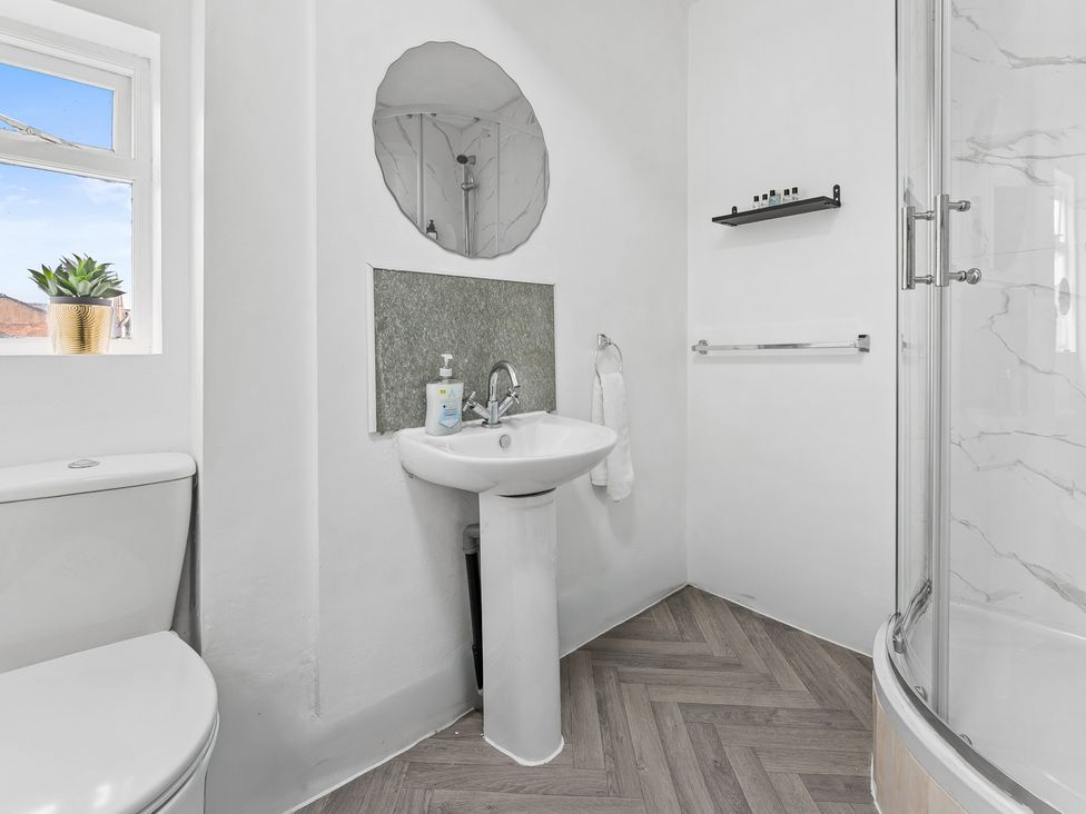 A bathroom with sink, toilet, mirror and shower at The Craftsman Birmingham City Apartment Birmingham