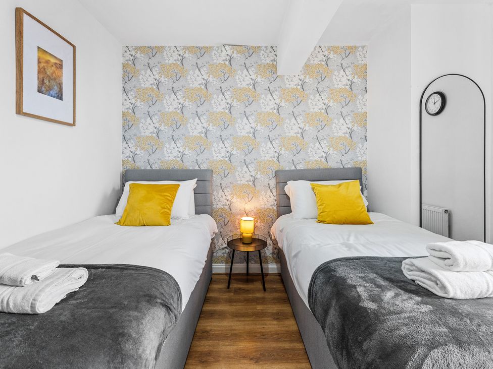 A bedroom with two beds and a table at The Craftsman Birmingham City Apartment in Birmingham