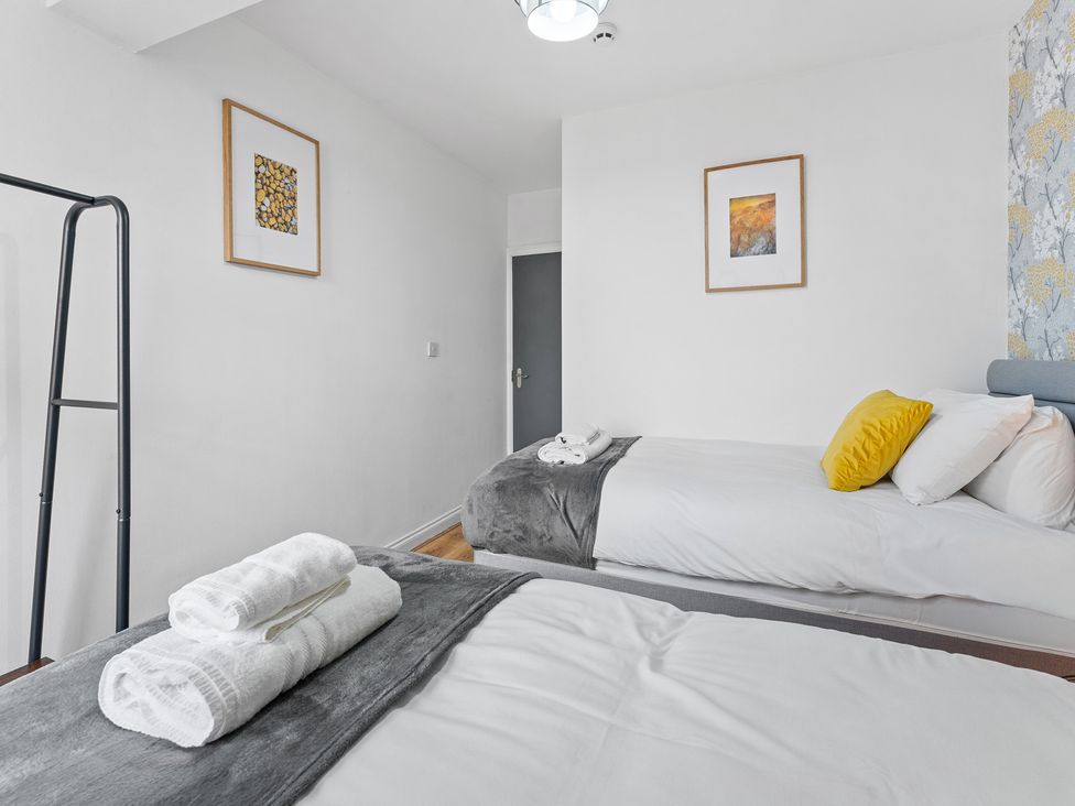 A bedroom with two beds and framed artwork at The Craftsman Birmingham City Apartment Birmingham