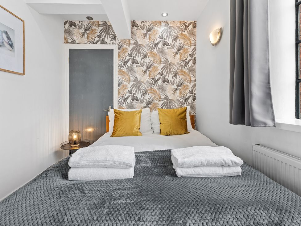 A bedroom with a double bed and floral wallpaper at The Craftsman Birmingham City Apartment Birmingham