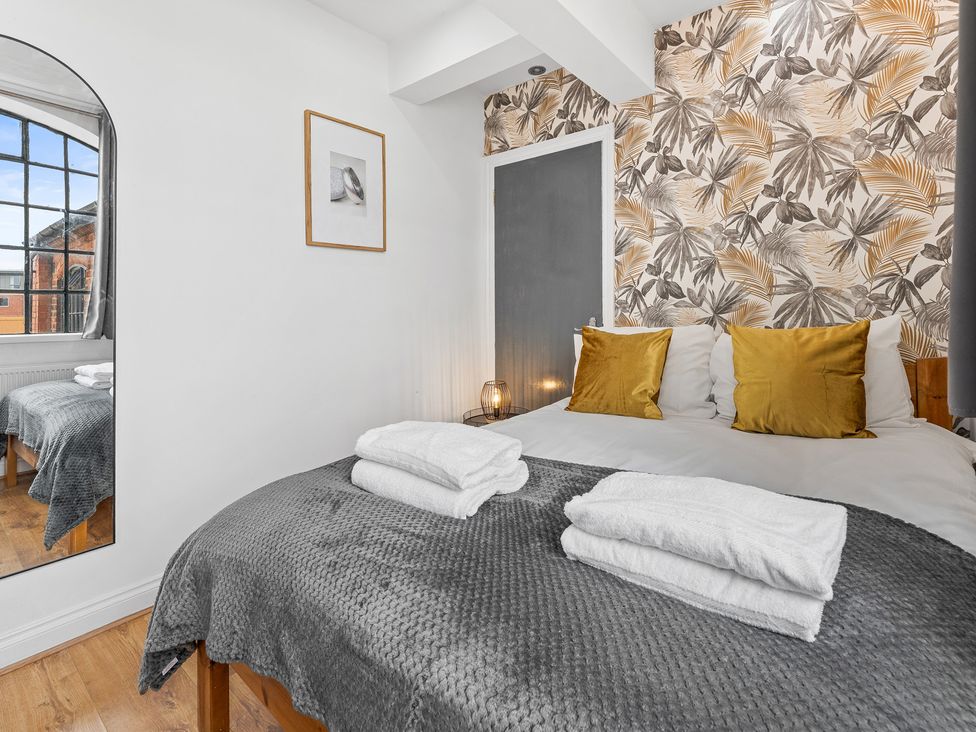 A bedroom with a bed and decorative elements at The Craftsman Birmingham City Apartment in Birmingham