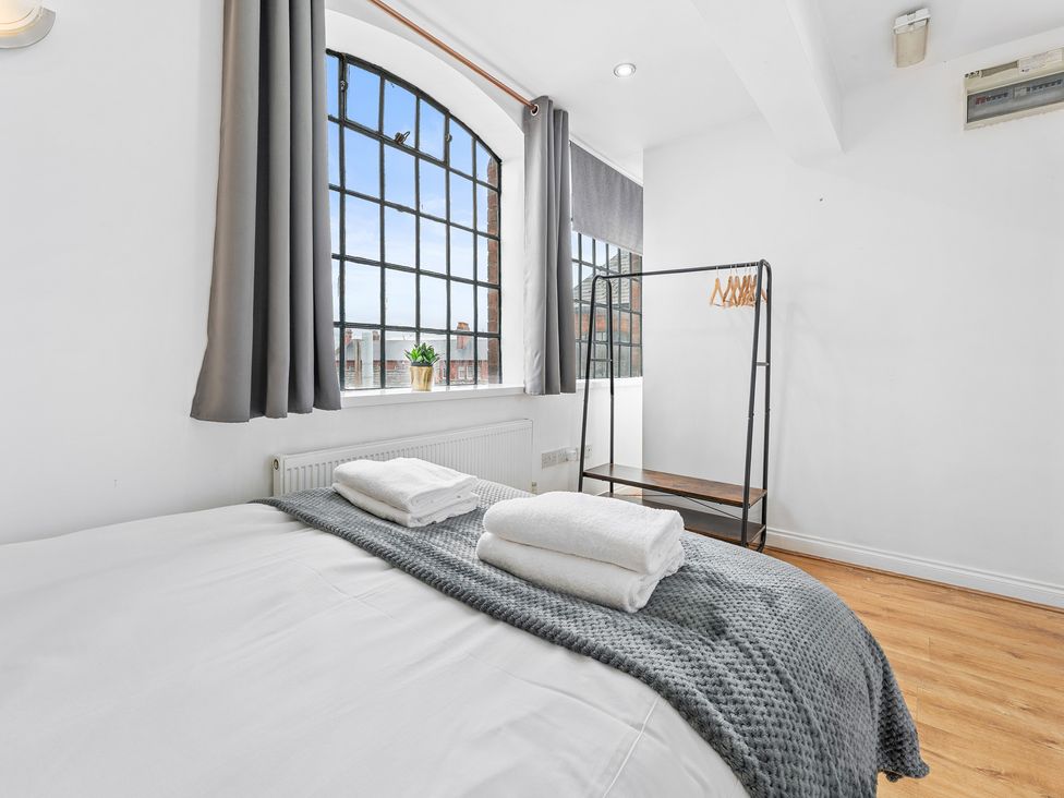 A bedroom with a bed and window at The Craftsman Birmingham City Apartment Birmingham