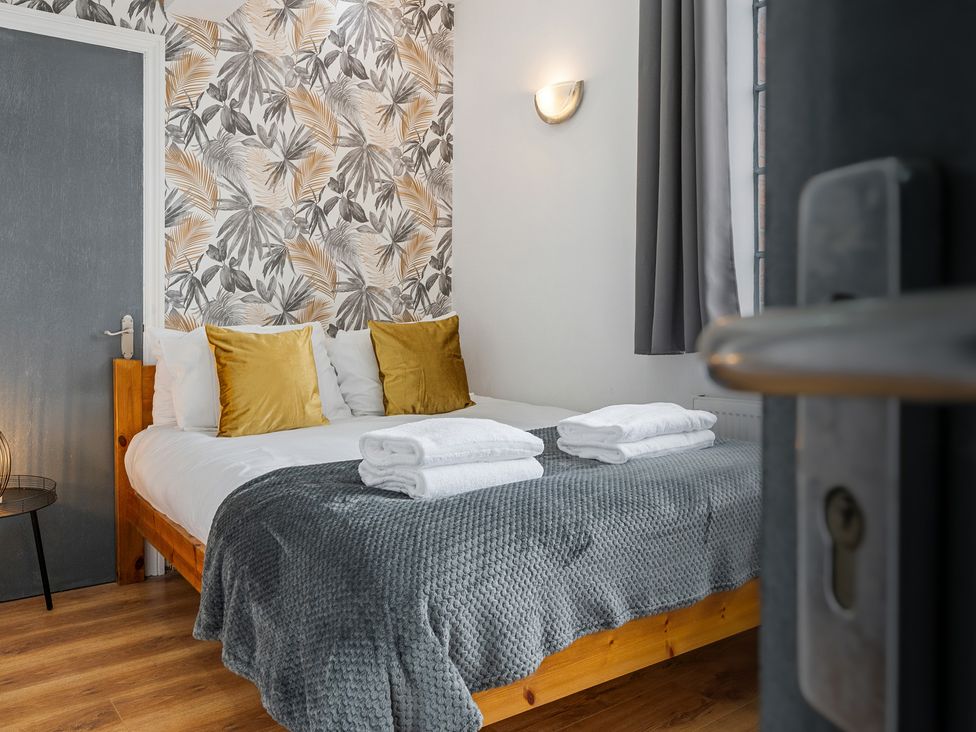 A bedroom with a bed and decorative wall at The Craftsman Birmingham City Apartment Birmingham