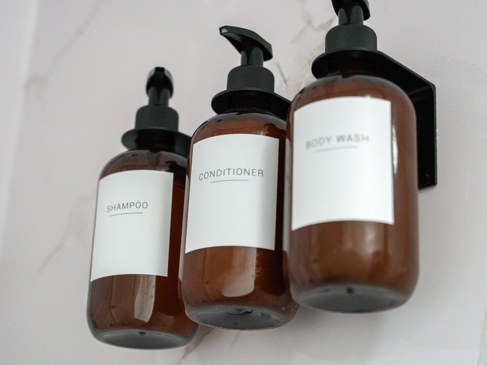Bottles of shampoo, conditioner, and body wash at The Craftsman Birmingham City Apartment in Birmingham