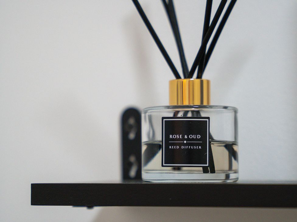 A reed diffuser on a shelf at The Craftsman Birmingham City Apartment Birmingham