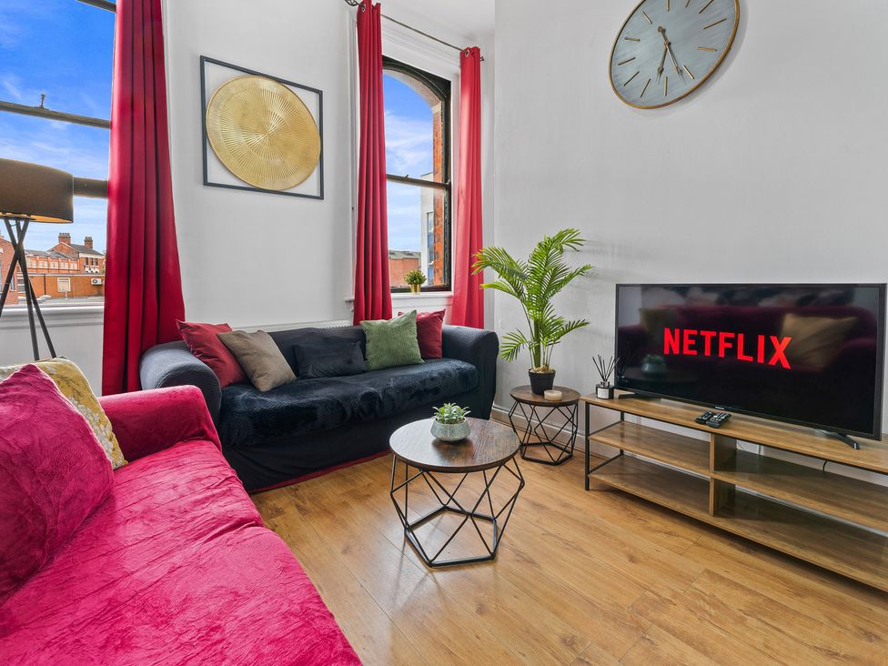 A living room with a tv displaying Netflix at The Goldsmith Birmingham City Apartment in Birmingham