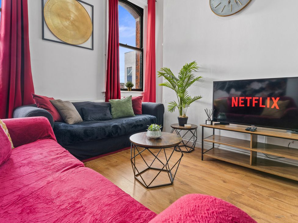 A living room with a sofa and TV at The Goldsmith Birmingham City Apartment Birmingham