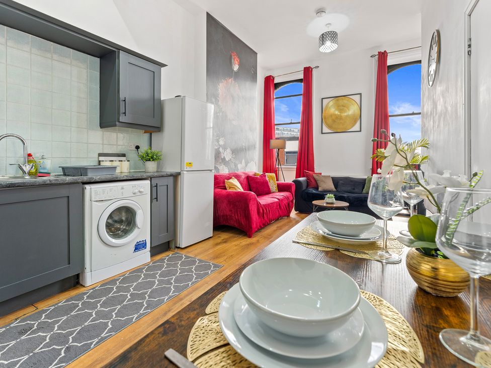 A kitchen with a washing machine and sofa at The Goldsmith Birmingham City Apartment Birmingham
