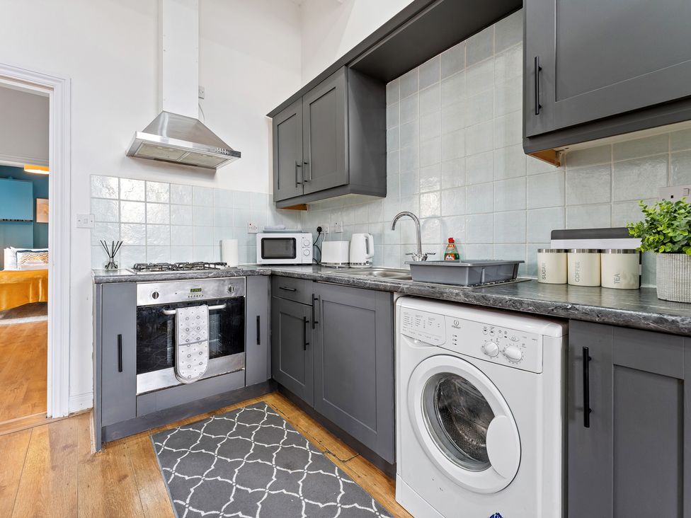 A kitchen with appliances and cabinets at The Goldsmith Birmingham City Apartment in Birmingham
