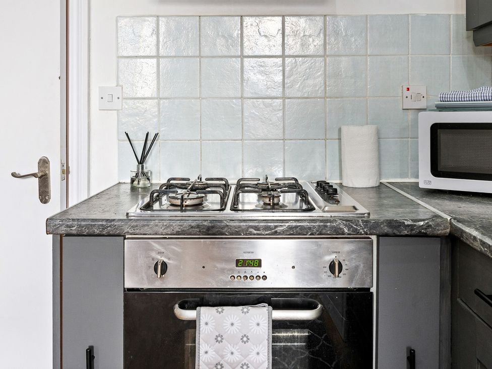 A kitchen with a stove and microwave at The Goldsmith Birmingham City Apartment, Birmingham