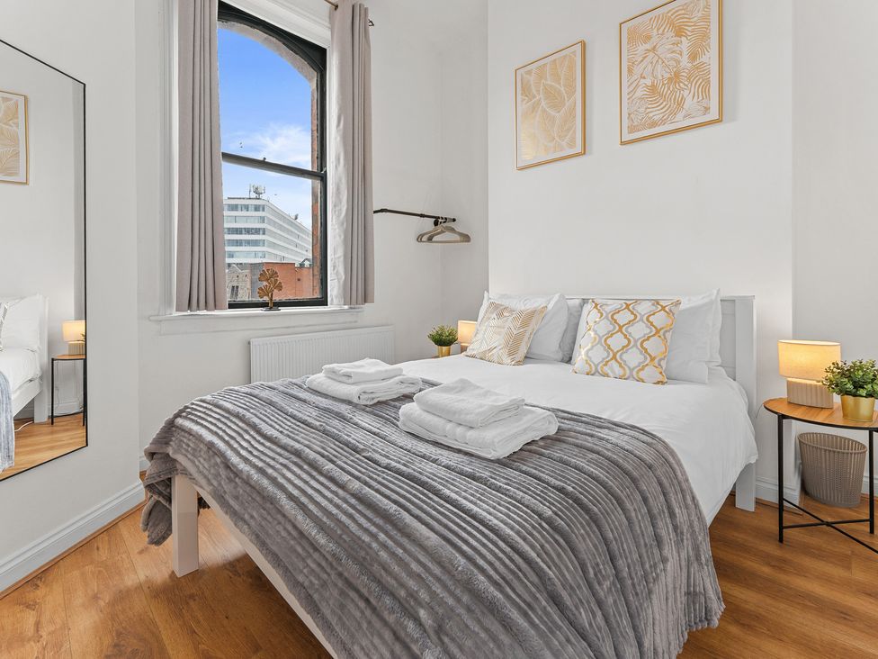 A bedroom with a bed and mirror at The Goldsmith Birmingham City Apartment Birmingham
