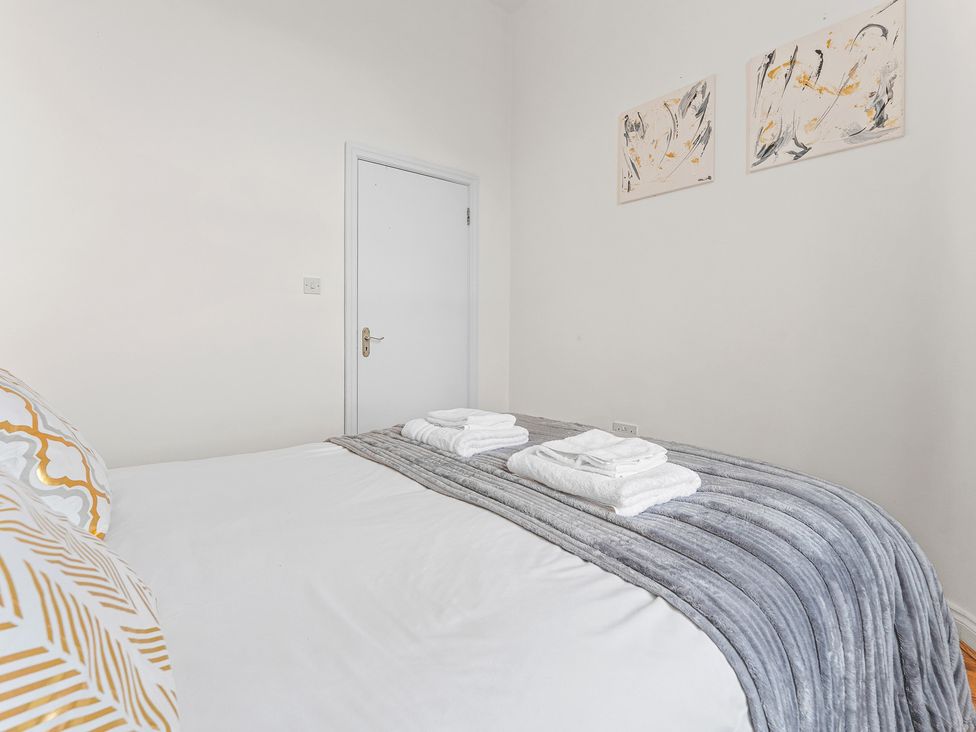A bedroom with a bed and towels at The Goldsmith Birmingham City Apartment Birmingham