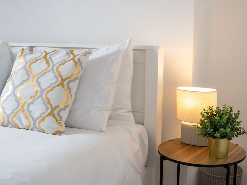A bed with a pillow and a lamp on a nightstand at The Goldsmith Birmingham City Apartment Birmingham
