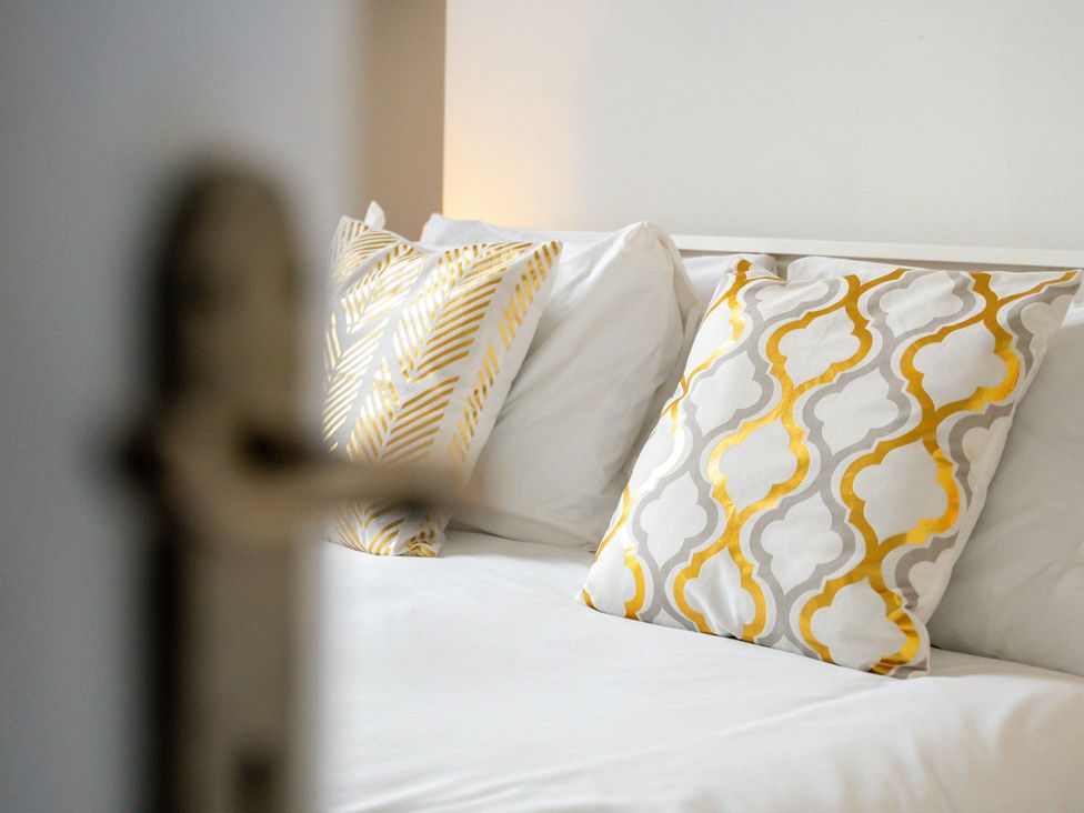 A bed with decorative pillows at The Goldsmith Birmingham City Apartment Birmingham