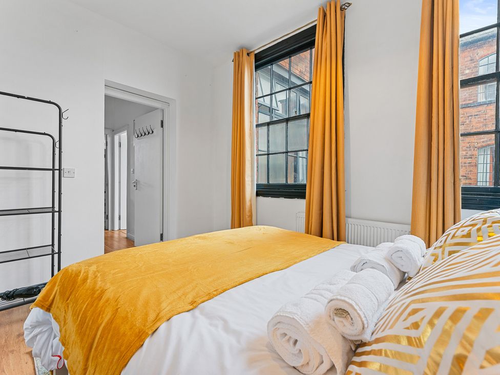 A bedroom with a bed and pillows at The Goldsmith Birmingham City Apartment Birmingham