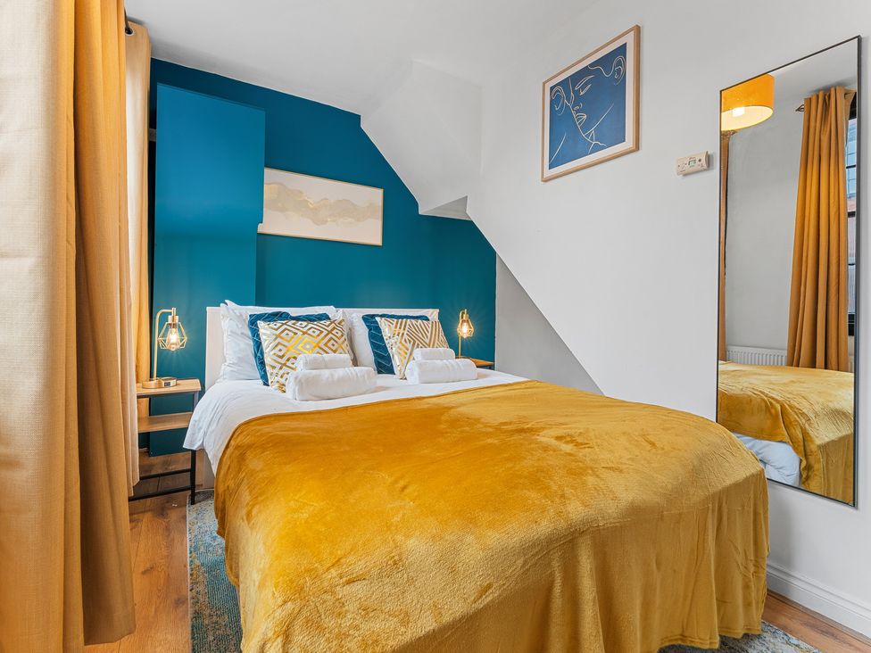 A bedroom with a bed and bedside table at The Goldsmith Birmingham City Apartment Birmingham
