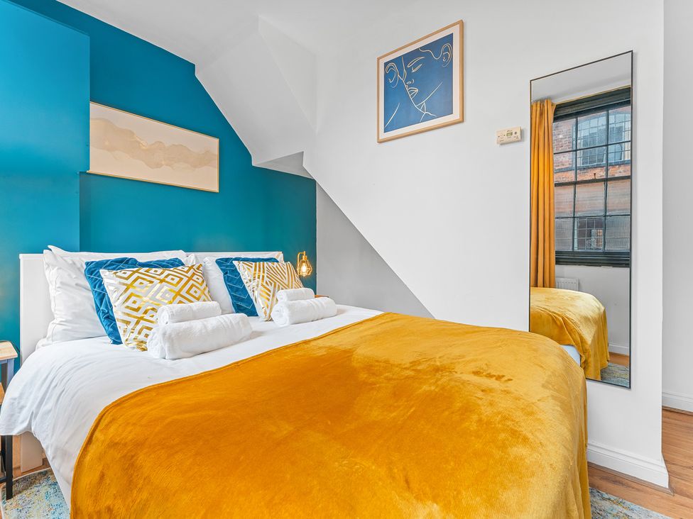 A bedroom with a bed and a mirror at The Goldsmith Birmingham City Apartment in Birmingham